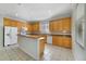 Kitchen featuring honey toned cabinets, an island with seating, tile backsplash, and stainless appliances at 2724 Amanda Kay Way, Kissimmee, FL 34744