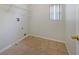 Neutral laundry room with tile floor, window with blinds, and wall-mounted shelving unit at 2724 Amanda Kay Way, Kissimmee, FL 34744