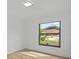 The bedroom has light wood floors and a window looking out onto the greenery of the neighborhood at 274 W 20Th St, Apopka, FL 32703