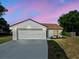 Charming single-story home with a white exterior, complemented by a two-car garage and a well-manicured lawn at 274 W 20Th St, Apopka, FL 32703