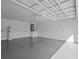 The large garage is unfinished with painted walls, a smooth painted floor, and open ceiling at 274 W 20Th St, Apopka, FL 32703