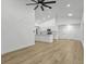 Spacious open-plan living area showcasing modern lighting, wood flooring, and access to the kitchen at 274 W 20Th St, Apopka, FL 32703