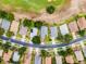 An aerial view shows a home with a well-kept lawn and a street lined with mature trees in a golf community at 3008 Pinnacle Ct, Clermont, FL 34711