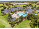 Beautiful aerial view of a community clubhouse with a large swimming pool, surrounded by lush landscaping and palm trees at 3008 Pinnacle Ct, Clermont, FL 34711