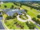 Stunning aerial view of a large community clubhouse and golf course, featuring lush landscaping, palm trees, and beautiful greenery at 3008 Pinnacle Ct, Clermont, FL 34711