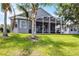 View of the backyard of a home with a screened-in patio and lawn at 3008 Pinnacle Ct, Clermont, FL 34711