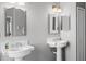 Updated bathroom featuring dual pedestal sinks, large mirrors, and modern fixtures at 3008 Pinnacle Ct, Clermont, FL 34711