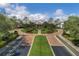 Elegant clubhouse entrance with manicured landscaping, roundabout, palm trees and American flags displayed proudly at 3008 Pinnacle Ct, Clermont, FL 34711