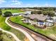 Aerial shot of a clubhouse featuring outdoor dining areas, lush landscaping, and golf course views at 3008 Pinnacle Ct, Clermont, FL 34711