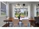 Elegant dining area with modern chandelier and views of the golf course through large windows and sliding doors at 3008 Pinnacle Ct, Clermont, FL 34711