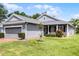 Well-maintained home with a grey exterior, landscaped front yard, and a brick driveway, offering curb appeal and comfort at 3008 Pinnacle Ct, Clermont, FL 34711