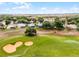 Scenic view of homes overlooking a well-manicured golf course with sand traps and automated sprinkler system under a clear blue sky at 3008 Pinnacle Ct, Clermont, FL 34711