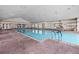 Bright indoor community pool featuring brick flooring, ample seating, and large windows at 3008 Pinnacle Ct, Clermont, FL 34711