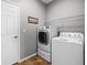 Laundry room with a front-load washing machine, dryer, and wire rack for storage at 3008 Pinnacle Ct, Clermont, FL 34711