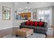 Cozy living room with a comfortable gray couch, patterned ottoman, and an open view of the modern kitchen at 3008 Pinnacle Ct, Clermont, FL 34711