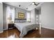 Bright primary bedroom with wood floors, neutral walls, ceiling fan, and ensuite bathroom access at 3008 Pinnacle Ct, Clermont, FL 34711