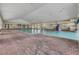 Spacious indoor pool area featuring brick flooring, bright natural light, and comfortable lounge seating at 3008 Pinnacle Ct, Clermont, FL 34711