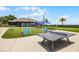 Outdoor recreation area with ping pong table, lawn games, picnic tables, and lush landscaping at 3008 Pinnacle Ct, Clermont, FL 34711