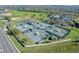 Aerial view of tennis courts near the clubhouse, surrounded by well-kept landscaping and a parking area at 3008 Pinnacle Ct, Clermont, FL 34711