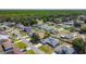 Aerial view shows a neighborhood of homes with roads, trees and nearby highway at 310 Cornwallis Ct, Kissimmee, FL 34758