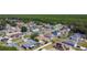 Real estate aerial view shows a neighborhood with houses, trees, roads and solar panels at 310 Cornwallis Ct, Kissimmee, FL 34758