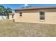 View of the backyard features exterior of home with grass and a nearby white fence at 310 Cornwallis Ct, Kissimmee, FL 34758