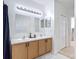 Bright bathroom featuring a double sink vanity, framed mirrors and a linen closet for ample storage at 310 Cornwallis Ct, Kissimmee, FL 34758