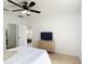 Bedroom with wood-look floors, a ceiling fan, and doorway to a bathroom at 310 Cornwallis Ct, Kissimmee, FL 34758