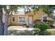 Home featuring front entrance framed by mature trees and tropical landscaping at 310 Cornwallis Ct, Kissimmee, FL 34758