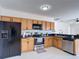 Functional kitchen with wood cabinets, stainless steel appliances, and sleek countertops at 310 Cornwallis Ct, Kissimmee, FL 34758