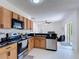 Efficient kitchen featuring stainless appliances, wooden cabinets, and a connecting dining space at 310 Cornwallis Ct, Kissimmee, FL 34758