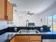 The kitchen sink has granite countertops and modern faucet, with a view to living room at 310 Cornwallis Ct, Kissimmee, FL 34758