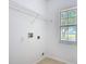 A sunlit laundry room boasts a window, shelving and washer/dryer hookups at 310 Cornwallis Ct, Kissimmee, FL 34758