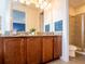 Bathroom with a double sink vanity, granite countertop, decorative wall art, and a glass-enclosed shower at 311 W Falls Dr, Kissimmee, FL 34747