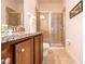 Bathroom featuring double vanity, granite countertops, and a glass-enclosed walk-in shower at 311 W Falls Dr, Kissimmee, FL 34747