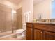Well-lit bathroom featuring a granite counter, wood cabinets, and glass enclosed shower at 311 W Falls Dr, Kissimmee, FL 34747