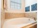 Close-up of a bathtub with tile surround and a window, offering a relaxing and well-lit space at 311 W Falls Dr, Kissimmee, FL 34747