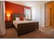 Comfortable bedroom featuring a queen-size bed, warm-colored wall, and a closet with sliding doors at 311 W Falls Dr, Kissimmee, FL 34747