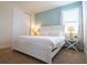 Bright bedroom featuring a crisp white bed, side tables with lamps and cool blue accent wall at 311 W Falls Dr, Kissimmee, FL 34747