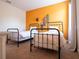 Bedroom with two twin beds, orange accent wall decorated with skateboards, and natural light at 311 W Falls Dr, Kissimmee, FL 34747