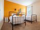 Bright bedroom featuring two twin beds, vibrant accent wall with skateboard decor, and a window with natural light at 311 W Falls Dr, Kissimmee, FL 34747