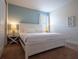Bright bedroom featuring a crisp white bed, side tables with lamps and cool blue accent wall at 311 W Falls Dr, Kissimmee, FL 34747
