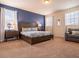 Bright bedroom featuring a large bed, blue accent wall, windows, and elegant bedside tables with lamps at 311 W Falls Dr, Kissimmee, FL 34747