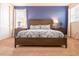 Bedroom with a large bed with blue and white patterned bedding, bedside tables, and large windows at 311 W Falls Dr, Kissimmee, FL 34747