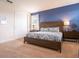 Comfortable bedroom featuring a large bed, blue accent wall, bedside tables with lamps, and ample closet space at 311 W Falls Dr, Kissimmee, FL 34747