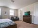 Cozy bedroom featuring a large bed, dresser with TV, chair, and neutral color scheme at 311 W Falls Dr, Kissimmee, FL 34747