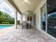 Covered patio with ceiling fans, outdoor dining furniture and view of pool at 311 W Falls Dr, Kissimmee, FL 34747
