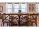 Elegant dining room boasts a glass table and seating for eight under bright natural light from three large windows at 311 W Falls Dr, Kissimmee, FL 34747