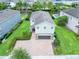 A two-story home with a well manicured lawn and landscaping, surrounded by other homes and palm trees at 311 W Falls Dr, Kissimmee, FL 34747