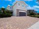 Attractive two-story home featuring a two-car garage, stone accents, and brick paved driveway at 311 W Falls Dr, Kissimmee, FL 34747